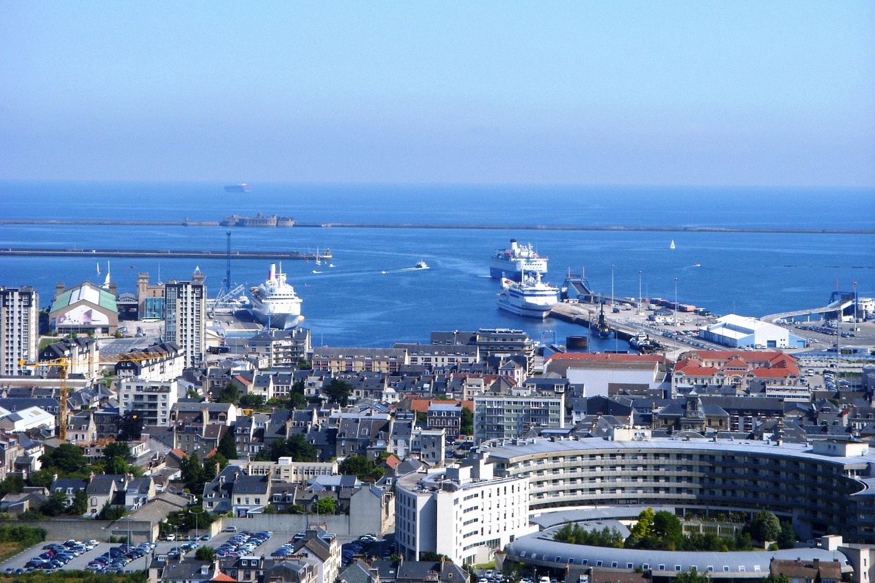 Blick über Cherbourg auf den Hafen mit Kreuzfahrtschiff und Fähre am Kai